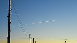 black electric post, sky, airplane, contrails