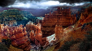 high angle photo of rock formations under black and white sky during daytime, bryce canyon