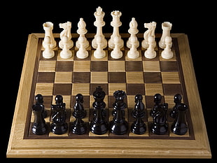 photo of white and black chess pieces on brown chess board