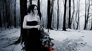 woman wearing black tube dress while holding red rose