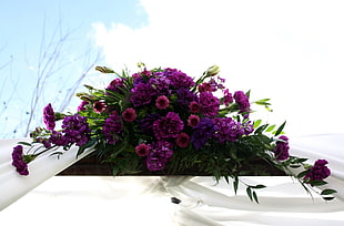 purple petaled flower arrangement on window