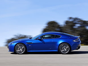 time lapsed photography of blue sports coupe cruising on gray concrete road