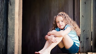 photograph of girl sitting near door