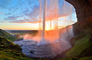 waterfalls near grass field during golden hour