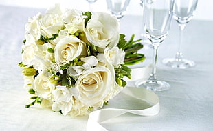 white rose centerpiece and clear glass wine glasses