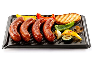 cooked hotdogs, vegetables, and bread on electric grill