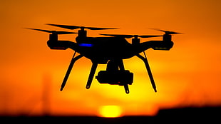 silhouette of quadcopter drone during sunset
