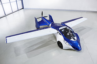 blue and white toy car with wings on white floor tiles