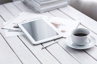 white tablet computer on brown table