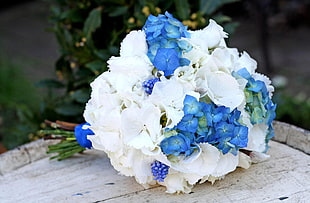 white and blue flower bouquet on brown wooden surface