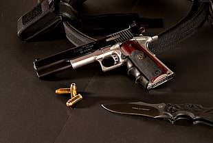 gray and black semi-automatic pistol near gray pocket knife