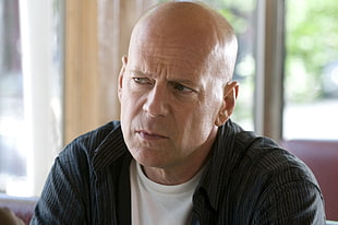 Bruce Willis wearing black dress shirt and white crew-neck shirt