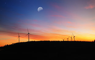 silhouette photography of wind turbines during golden hour HD wallpaper