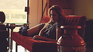 woman resting on red sofa in living room