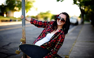 woman in red and black flannel holding pole in tilt-shift photography HD wallpaper