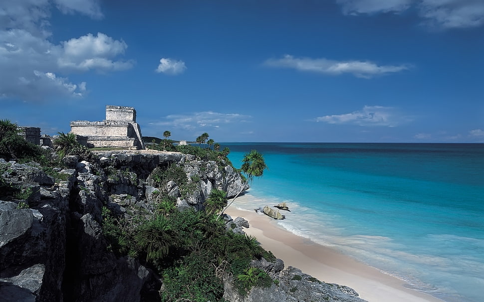 white stone castle near seashore under calm sky HD wallpaper