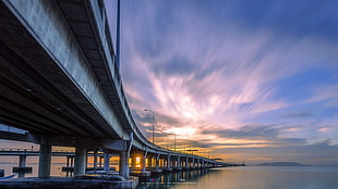 photograph of gray wooden bridge under blue sky, penang bridge