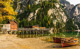 two brown canoes, boat, dock, lake, mountains