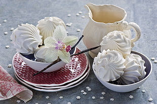 several white pastries on white ceramic bowls near white pitcher
