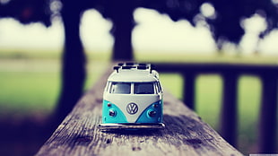 shallow focus photography of teal and white Volkswagen Samba die-cast toy car