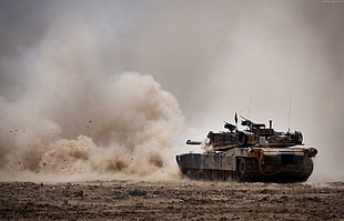 photo of brown battle tank in desert during day time