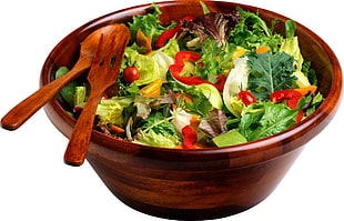 salad in brown wooden bowl with spoon and fork