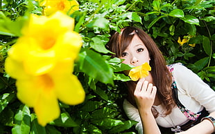 woman holding yellow Allamanda flower