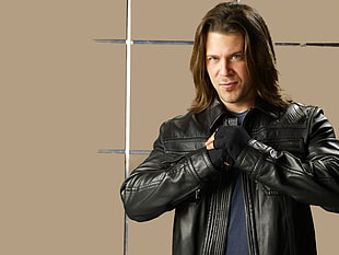 man wearing black leather zip-up jacket near brown wall HD wallpaper