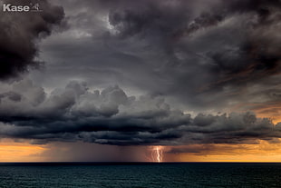 seawater under gray clouds and lightning