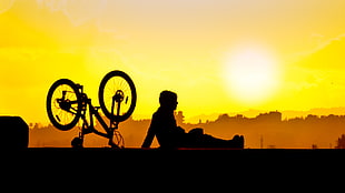 man sitting on ground during sunset HD wallpaper