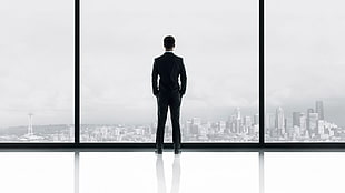 photography photo of man in suit-jacket outfit standing in front glass wall building