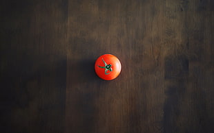 red tomato on brown surface
