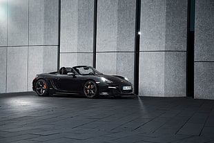 black Porsche 911 parked on black tiled building