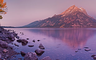 mountain beside body of water photo during sunset