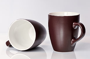 two brown-and-white ceramic mugs