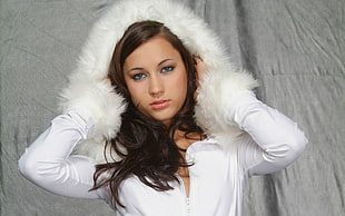 woman wearing white fur-skin parka hoodie near gray textile