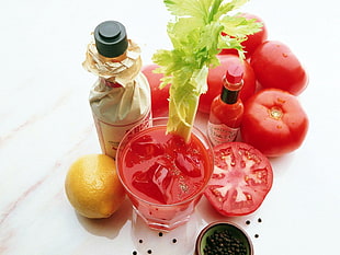 food photography of tomato juice beside Tobasco hot sauce and bunch of tomatoes