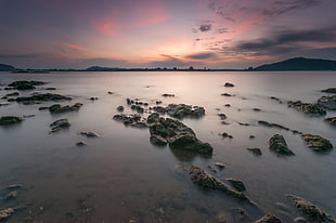 Rocks on Body of Water during Sunset HD wallpaper