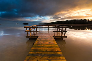 brown wooden dock on body of water during golden hour
