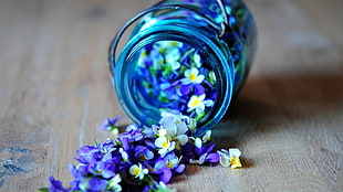 purple and white flowers on blue tint glass mason jar