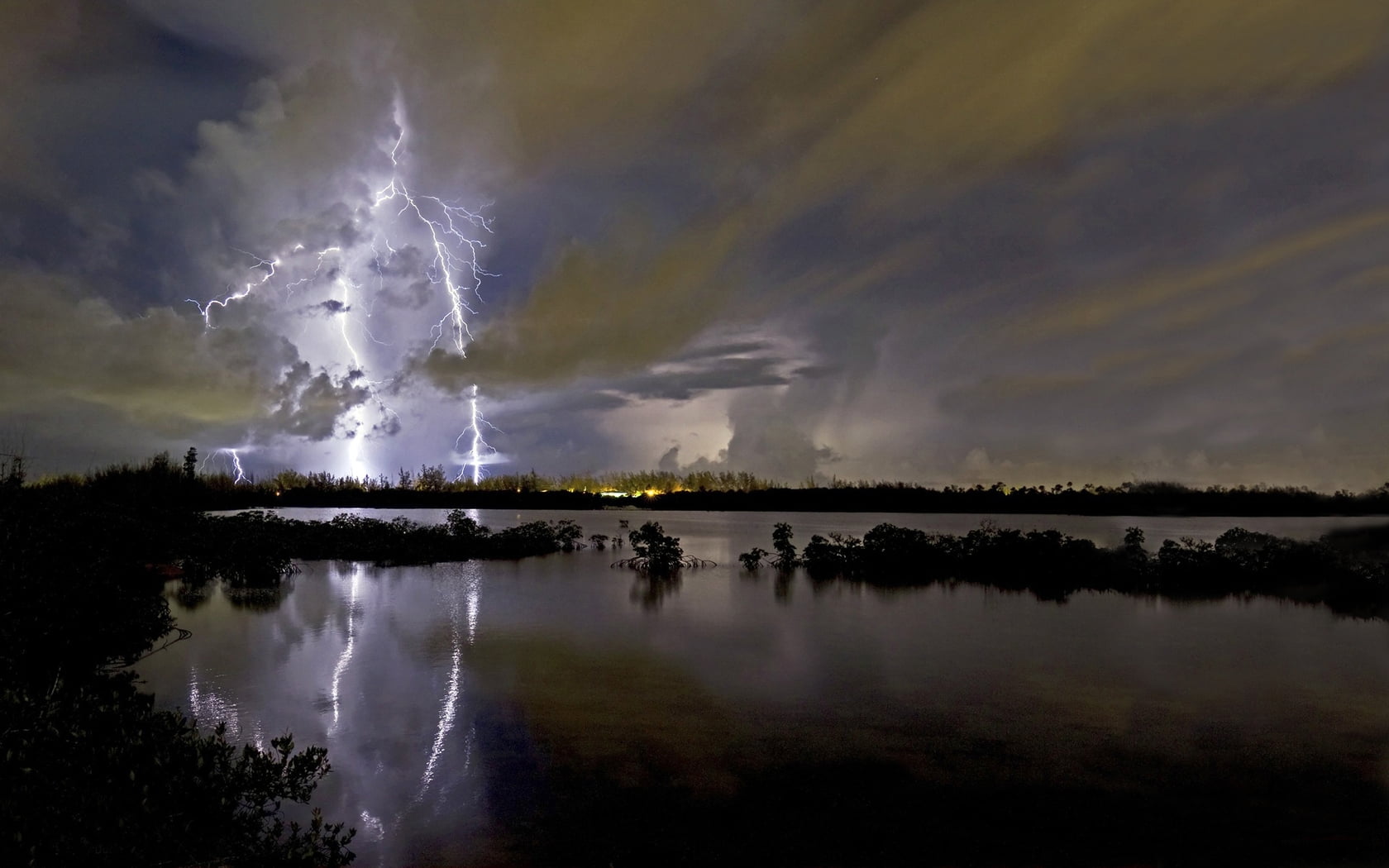 photo of thunder near body of water during night time