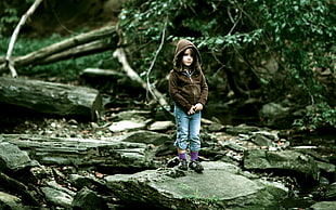 girl standing on stone near tree