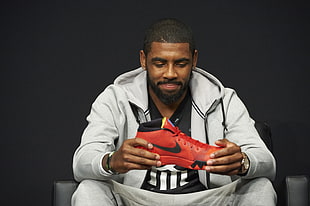 person holding red nike basketball shoes