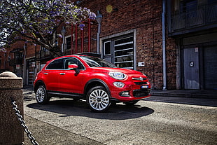 red FIAT 500 park ahead near brown concrete building HD wallpaper