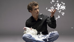 man holding hen and feathers