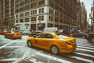 yellow taxi cab driving through the city HD wallpaper