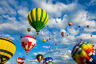 assorted hot air balloons under gray clouds during daytime