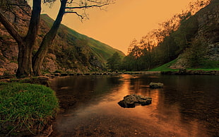 panoramic photography of mountains near the river at sunset