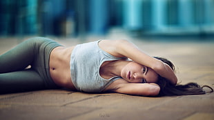 woman in grey crop top lying on floor