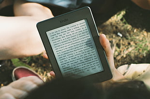person holding Kindle E-book reader